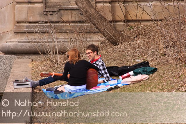 Two people play guitar and listen to the old vinyl near Lake of the Isles.